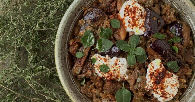 Aubergine and puy lentils stew with Greek yoghurt, fresh oregano leaves, dried thyme and Ethiopian berbere spice blend close-up.