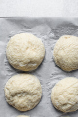Boiled pretzel buns dough on a baking sheet, German laugenbroetchen, boiled lye buns  dough on a baking tray, process of making pretzel buns