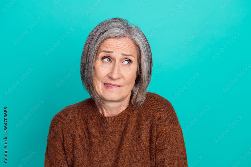 Sticker photo of nervous aged person biting lips look interested empty space isolated on aquamarine color ba