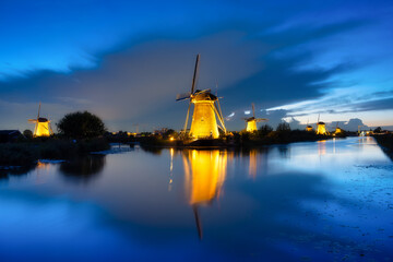 Fototapeta na wymiar Kinderdijk National Park in the Netherlands. Windmills at dusk. A natural landscape in a historic location. Reflections on the water surface. Dutch canals. UNESCO World Heritage Site.