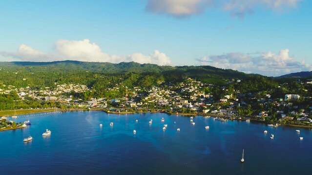 Aerial view of the picturesque maritime city of Santa Barbara. White sailboats and yachts on the blue water of the ocean. Orbital drone shot. Beautiful scenery of the Caribbean coast.