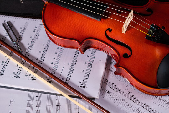Viejo viol&iacute;n de estudio en su estuche, sobre partituras de m&uacute;sica