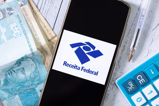 RFB - Receita Federal. Um telefone celular com a logo da Receita Federal do Brasil e uma calculadora na composi&ccedil;&atilde;o da imagem. Imposto de renda, darf, declara&ccedil;&atilde;o anual, restitui&ccedil;&atilde;o do imposto de renda.