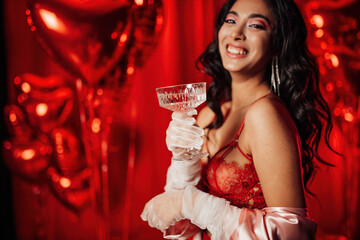 Portrait of happy smiling sexy asian girl glam makeup in red lingerie with coupe champagne glass