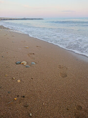 Sandy beach of the sea. footprints in the sand. Twilight, Evening