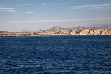 Fototapeta premium Beautiful blue sea. Sunny evening. Mountains and desert on the coast. Colorful sea landscape.