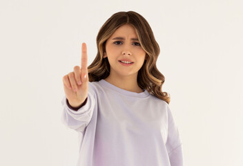 Serious and angry caucasian woman telling to stop, frowning and showing finger in disapproval, prohibit something, standing in dress against white background