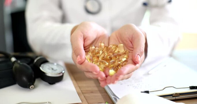 Doctor holding gorse gelatin capsules of omega 3 fatty acids closeup 4k movie slow motion 