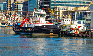 Fototapeta na wymiar Powerful tug boat and small tender in harbour