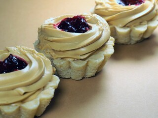Cupcakes with cream and jam. A close-up of a sweet dessert. Pastry products