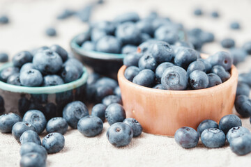 Three ceramic bowls with blueberries and berries scattered around.