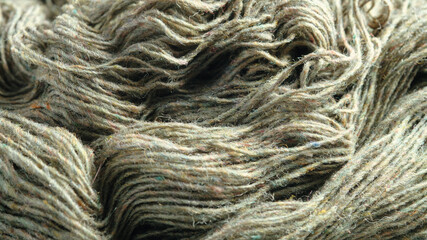 Threads of natural organic sheep wool. Unwound skein of olive green knitting yarn.