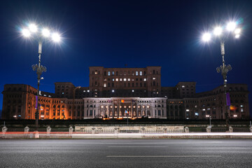 Obraz premium Night in Bucharest. Night rush hour traffic long exposure on the boulevard street in front of Palace of Parliament landmark building from Romania.