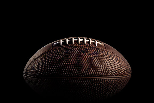 Close up of an American football on dark background.