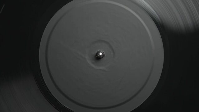Black vinyl record with music spinning on turntable in overhead video clip