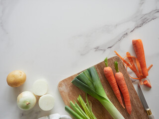 Fresh vegetables for a healthy diet. Carrot, leek, onion and potato on the marble kitchen...