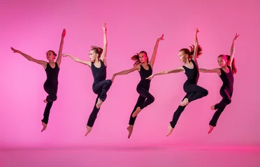 Wall murals Dance School Сhildren dancing. Group of children, little girls in sportive style clothes dancing in choreography class isolated on background in neon light.