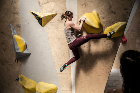 Athletic young woman on rock climbing wall