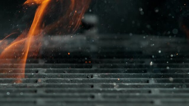 Close-up of iron cast grate with fire flames and sparks, super slow motion, filmed on high speed cinematic camera at 1000 fps.