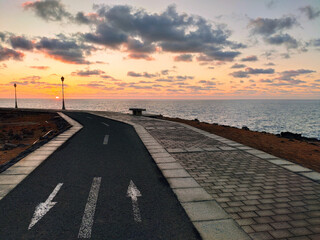 Fototapeta premium Bicycle trail in front of the sea at sunrise, Caleta de Fuste, Fuerteventura, Spain