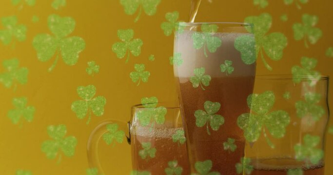 Animation of st patrick's day green shamrock falling over beer glasses