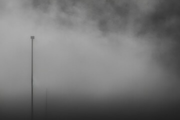 Abstract fog on a black background. Beautiful swirling gray smoke in the shape of a mockup for your logo. The white cloudiness, mist, or smog is perfect for use as a wide-angle horizontal wallpaper or