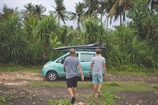 Rear view of friends walking towards car