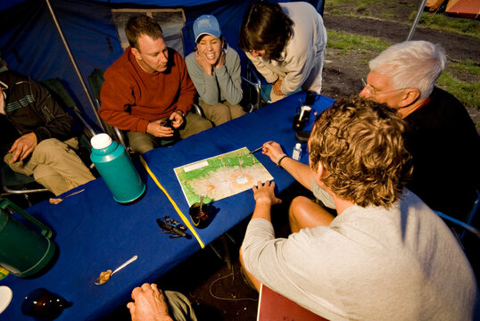 A team of hikers discuss the next day's plans on their way to the summit of Mt. Kilimanjaro.