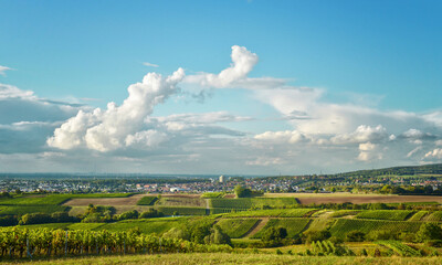 Two cloud systems connecting in arch shape over vineyards in Germany.
