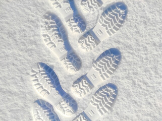 shoe prints in the snow. human feet traces in the snow. snow pathway. winter background