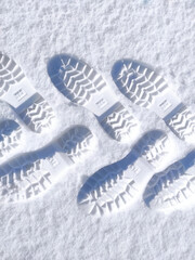 shoe prints in the snow. human feet traces in the snow. snow pathway. winter background
