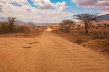 Fototapeta na wymiar A dirt road against the background of Ndoto Mountains in Kenya
