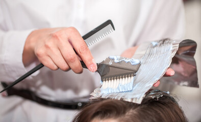Hairdresser stylist takes care of girl's hair. Hair care procedures in a beauty salon. Hair...