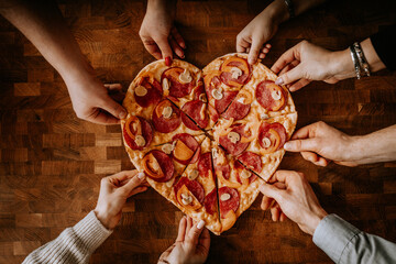 Pizza hands. Several hands take pizza at the same time, view above. Hot tasty take out pizza from the box for group of people. Square composition.