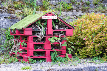 bee and insect house mounted on recycled pallets, painted in bright colors, in an outdoor park in Ireland.