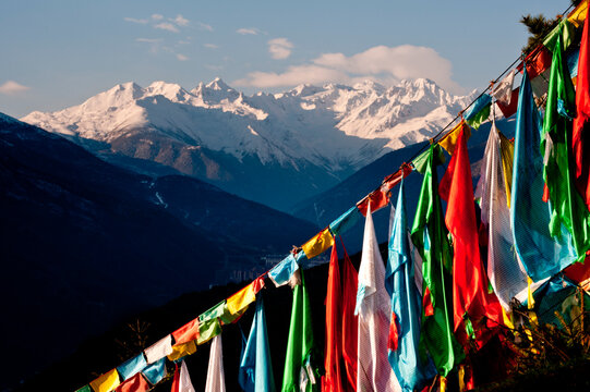 Prayer flags in frnot of snow covered mountains.  Kangding, Sichuan, China (Tibet)