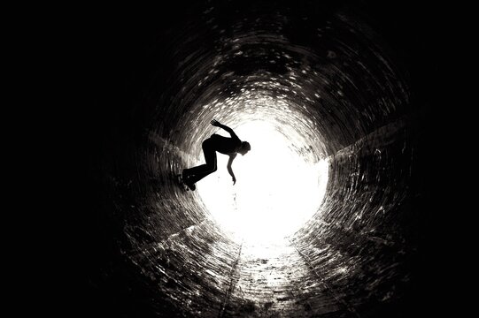 Skateboarder in Drainage Pipe