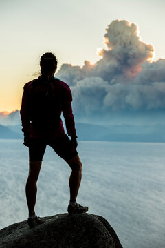 A mountain biker stops on the Flume Trail to watch smoke from a wildfire.