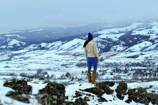 Woman Stands On A Rock Above The Small Town Of Council, Idaho In Winter