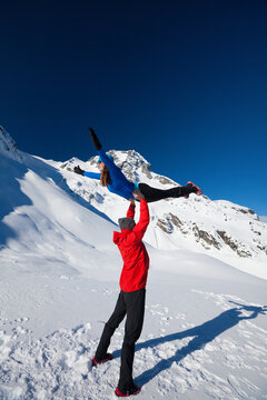 A fit young couple preform acrobatic yoga (bird pose) below Joffre Peak.
