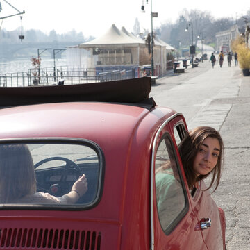 Teen girl looks out Fiat 500 window