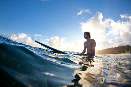 A young man surfing into the light at Monster Mush, on the north shore of Oahu, Hawaii.