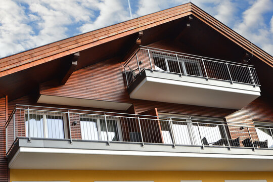 Typische Front mit Balkon und Erker eines mittleren tiroler Beherbergungsbetriebs in alpiner Holz-Architektur (Österreich)