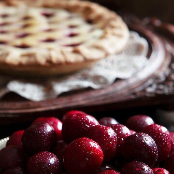 fresh cherries ,cooked pie in the background blured for text overlay