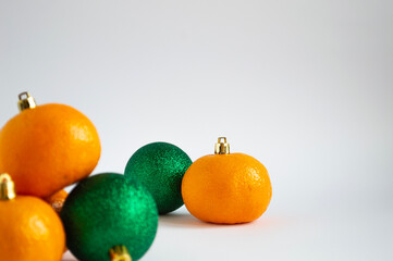 New Year's toys and tangerines that look like toys lie in a heap.  Green and orange colors.  Place for text.