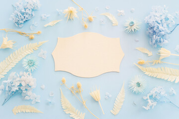 Top view image of white dry flowers over pastel blue background .Flat lay