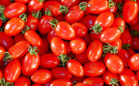 Bright red cherry tomatoes top view close up, natural vegan food background.