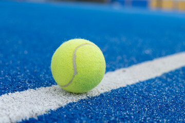 selective focus, close-up view of a ball on the line of a paddle tennis court. Racket sports concept