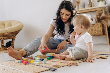 Communication between mother and child. Love and kindness in the family. The kid plays with wooden eco-friendly toys.
