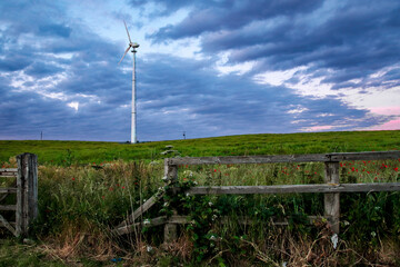 Fototapeta na wymiar fence in the field with wind turbine